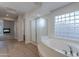 Bright bathroom with a large soaking tub and a glass block window for natural light at 13305 W Colter St, Litchfield Park, AZ 85340