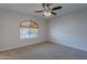 Cozy bedroom featuring carpet flooring, a ceiling fan, and an arched window for natural light at 13305 W Colter St, Litchfield Park, AZ 85340