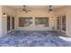 Inviting covered patio with ceiling fans, stone floors, and a view of the lush backyard at 13305 W Colter St, Litchfield Park, AZ 85340