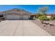 Well-maintained single-story home with a three-car garage, desert landscaping, and a clear blue sky at 13305 W Colter St, Litchfield Park, AZ 85340