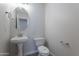 Charming half bathroom featuring a pedestal sink, modern toilet, and stylish fixtures at 13305 W Colter St, Litchfield Park, AZ 85340