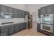 Spacious kitchen equipped with stainless steel appliances, gray cabinets, and quartz countertops, open to living spaces at 13305 W Colter St, Litchfield Park, AZ 85340