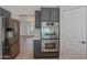 Gourmet kitchen with stainless steel refrigerator, double oven and gray cabinetry, seamlessly connecting to the living spaces at 13305 W Colter St, Litchfield Park, AZ 85340
