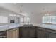 Open-concept kitchen featuring stainless steel appliances, gray cabinetry, and a spacious island with quartz countertops at 13305 W Colter St, Litchfield Park, AZ 85340