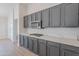 Modern kitchen showcasing sleek gray cabinets, stainless steel appliances, and stylish quartz countertops at 13305 W Colter St, Litchfield Park, AZ 85340