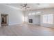 Bright open living room with fireplace, ceiling fan, large windows, and luxury vinyl flooring at 13305 W Colter St, Litchfield Park, AZ 85340