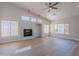Bright living room featuring a fireplace, large windows and contemporary ceiling fan at 13305 W Colter St, Litchfield Park, AZ 85340