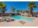 Inviting backyard pool with mature palm trees, landscaping, and sunny patio area at 13305 W Colter St, Litchfield Park, AZ 85340