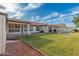 Spacious backyard with a covered patio, pool, lush lawn, and desert landscaping at 13629 N 71St Dr, Peoria, AZ 85381