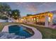 Backyard with a private pool, patio, dining set, lush lawn and beautiful desert landscaping at 13629 N 71St Dr, Peoria, AZ 85381