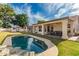 Beautiful backyard featuring a private pool with a rock feature, lush lawn, and desert landscaping at 13629 N 71St Dr, Peoria, AZ 85381