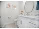 Bright bathroom with a white vanity, marble countertop, round mirror, and modern fixtures at 13629 N 71St Dr, Peoria, AZ 85381