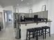 Open kitchen with bar seating, modern appliances, and neutral-toned cabinetry at 13629 N 71St Dr, Peoria, AZ 85381