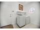Laundry room with washer, dryer, octagon shaped window and door to exterior at 13629 N 71St Dr, Peoria, AZ 85381