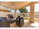 Inviting covered patio with seating overlooks pool with a rock waterfall feature at 13629 N 71St Dr, Peoria, AZ 85381