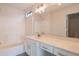 Bright bathroom with a shower, bathtub, and vanity with white cabinets and a large mirror at 13706 N 130Th Ave, El Mirage, AZ 85335