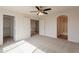 Spacious bedroom with a ceiling fan, carpeted floor and adjoining bathroom at 13706 N 130Th Ave, El Mirage, AZ 85335