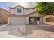 Two-story home with a two car garage, desert landscaping, and a welcoming front porch at 13706 N 130Th Ave, El Mirage, AZ 85335