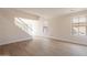 Bright living room with laminate floors, large windows, and staircase with white banister at 13706 N 130Th Ave, El Mirage, AZ 85335