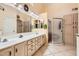Well-lit bathroom with double sinks, white cabinets, and a glass-enclosed shower at 14680 W Morning Star Trl, Surprise, AZ 85374