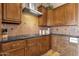 Kitchen featuring wooden cabinetry, stone countertops, and stainless steel hood at 15620 E Palomino Blvd, Fountain Hills, AZ 85268