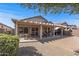Outdoor patio with dining and relaxing areas, set against a beautifully landscaped backyard with greenery and clear skies at 16232 W Montoya Dr, Surprise, AZ 85374