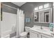 Cozy gray-toned bathroom featuring a shower-tub combo, toilet, sink, and vanity with a stylish mirror at 16232 W Montoya Dr, Surprise, AZ 85374
