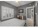 Bedroom featuring a bed frame, window with shutters, and view of another room at 16232 W Montoya Dr, Surprise, AZ 85374