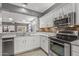 Modern kitchen featuring stainless steel appliances, granite countertops, white cabinets, and attractive backsplash at 16232 W Montoya Dr, Surprise, AZ 85374