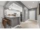 Modern kitchen features a breakfast bar with pendant lights, white cabinets, and sleek countertops at 16232 W Montoya Dr, Surprise, AZ 85374