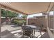 Covered patio featuring outdoor dining set overlooking a landscaped yard with mature trees at 16232 W Montoya Dr, Surprise, AZ 85374