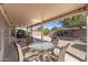 Comfortable covered patio with a round glass table, wicker chairs, and outdoor grill, great for entertaining guests at 16232 W Montoya Dr, Surprise, AZ 85374