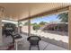 Relaxing covered patio with furniture, BBQ, and views of the landscaped backyard with block wall at 16232 W Montoya Dr, Surprise, AZ 85374