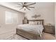Neutral bedroom with ceiling fan, rug, and bedside tables on each side of the bed at 17431 W Via De Luna Dr, Surprise, AZ 85387