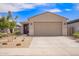 Charming single-story home showcasing a two-car garage and low-maintenance desert landscaping under a bright blue sky at 17431 W Via De Luna Dr, Surprise, AZ 85387