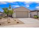 Charming single-story home showcasing a two-car garage and low-maintenance desert landscaping under a bright blue sky at 17431 W Via De Luna Dr, Surprise, AZ 85387