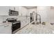 Modern kitchen with stainless steel appliances, granite countertops, and a breakfast bar at 17431 W Via De Luna Dr, Surprise, AZ 85387