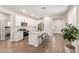 A modern kitchen with white cabinets, subway tile backsplash, stainless steel appliances, and a center island with seating at 17431 W Via De Luna Dr, Surprise, AZ 85387