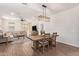 A spacious living room and dining area featuring wood-look tile, neutral colors, and a comfortable sectional sofa at 17431 W Via De Luna Dr, Surprise, AZ 85387