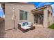 Relaxing patio with a woven daybed, umbrella, and access to a covered outdoor kitchen area at 17431 W Via De Luna Dr, Surprise, AZ 85387