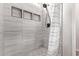 Modern shower with pebble base, stylish tile work, and built-in shelving at 17431 W Via De Luna Dr, Surprise, AZ 85387
