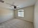 Spacious bedroom with carpet flooring, fan, and windows bringing in natural light at 17477 W Woodrow Ln, Surprise, AZ 85388