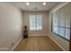Bright bedroom features wood-look floors, neutral walls, and two windows with blinds at 17477 W Woodrow Ln, Surprise, AZ 85388