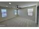 Large bedroom with neutral carpet, ceiling fan, and windows allowing ample natural light at 17477 W Woodrow Ln, Surprise, AZ 85388