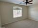 Spacious bedroom with carpet flooring, fan, and windows bringing in natural light at 17477 W Woodrow Ln, Surprise, AZ 85388