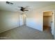 Spacious bedroom with carpet flooring, fan, closet, and doorway to another room at 17477 W Woodrow Ln, Surprise, AZ 85388