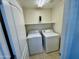 Functional laundry room featuring appliances, shelving and tiled flooring at 17477 W Woodrow Ln, Surprise, AZ 85388
