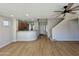 Spacious open-concept living area with wood-look floors, kitchen view, and carpeted stairs at 17477 W Woodrow Ln, Surprise, AZ 85388