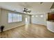 Large living area with wood-look floors, a ceiling fan, and a sliding glass door at 17477 W Woodrow Ln, Surprise, AZ 85388