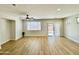 Bright open-concept living room features laminate floors, neutral walls, and a ceiling fan at 17477 W Woodrow Ln, Surprise, AZ 85388